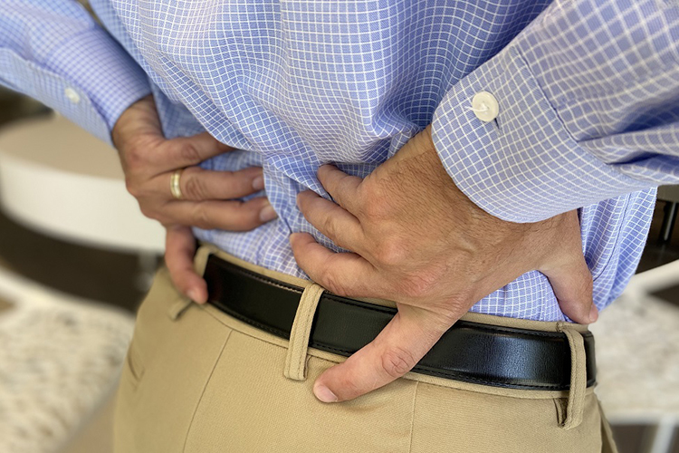 person with hands on their back