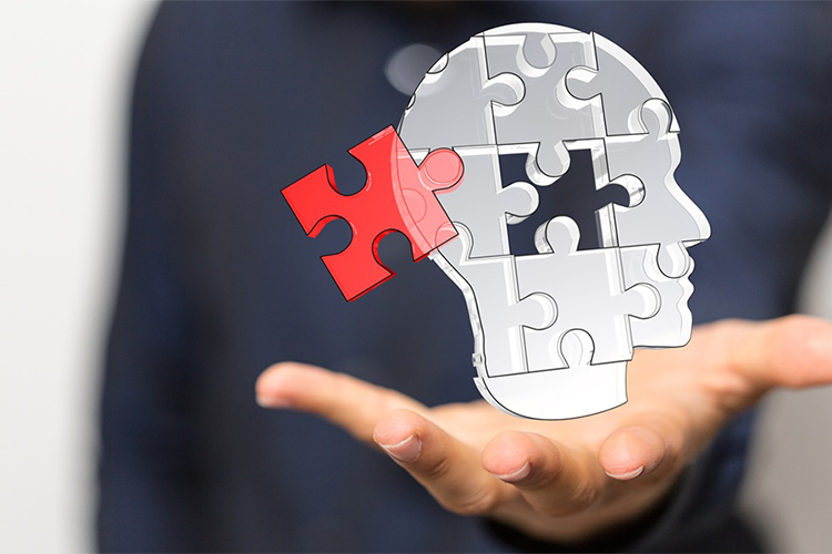 abstract image of hand hold out a puzzle-piece shape of a head in profile