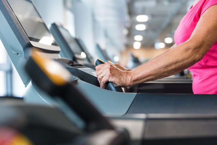 woman in pink shirt walking on treadmill