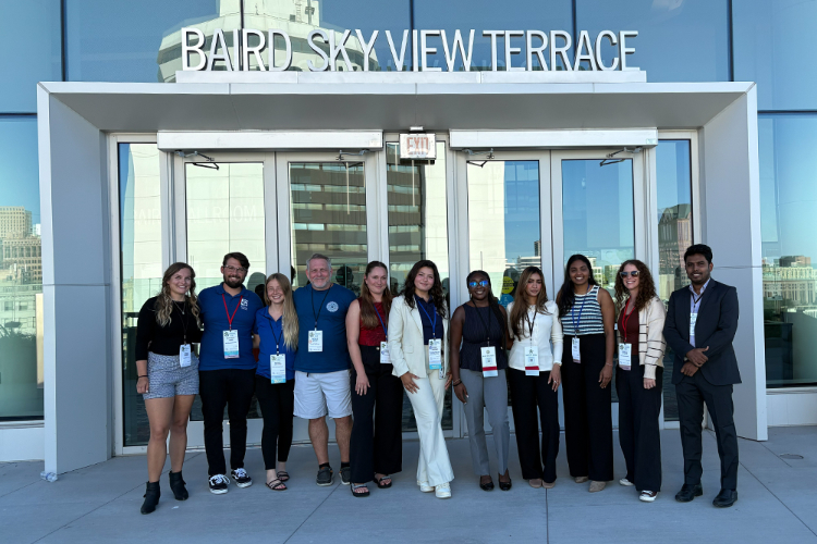 Group of people standing in front of building with name 'Baird Sky View Terrace'