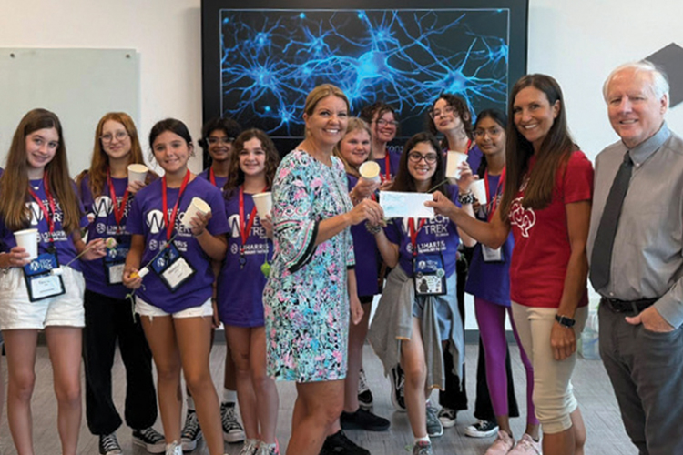 Group of students in blue t-shirts with red ribbons