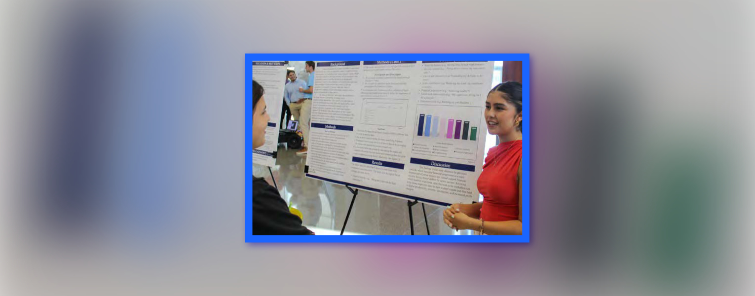 two people smiling standing next to a large graph on an easel