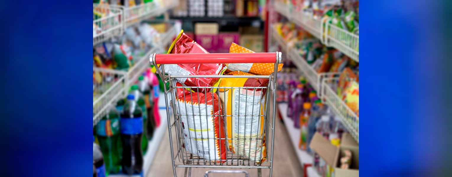 grocery cart full of junk food in an aisle of junk food