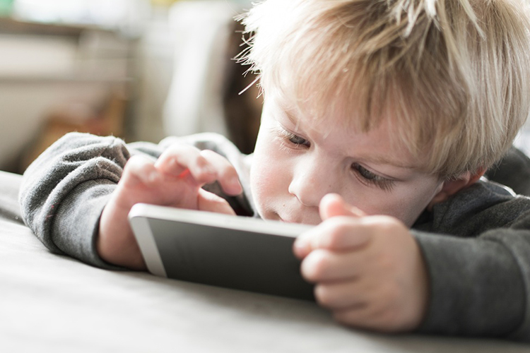 child looking at mobile device