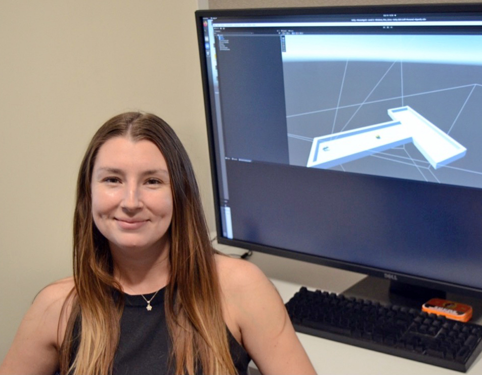 Jennifer next to one of her first projects, creating a simulated lab mouse and T-maze experiment environment.