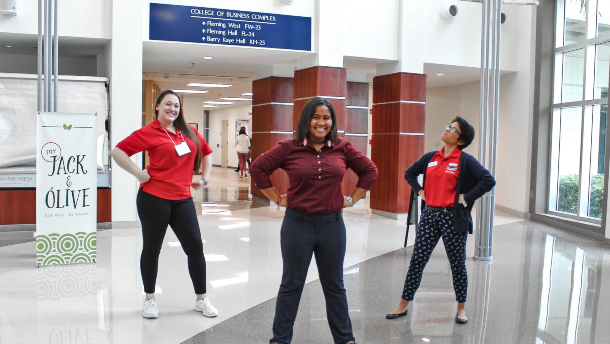 Three female student leaders posing within the College of Business Complex