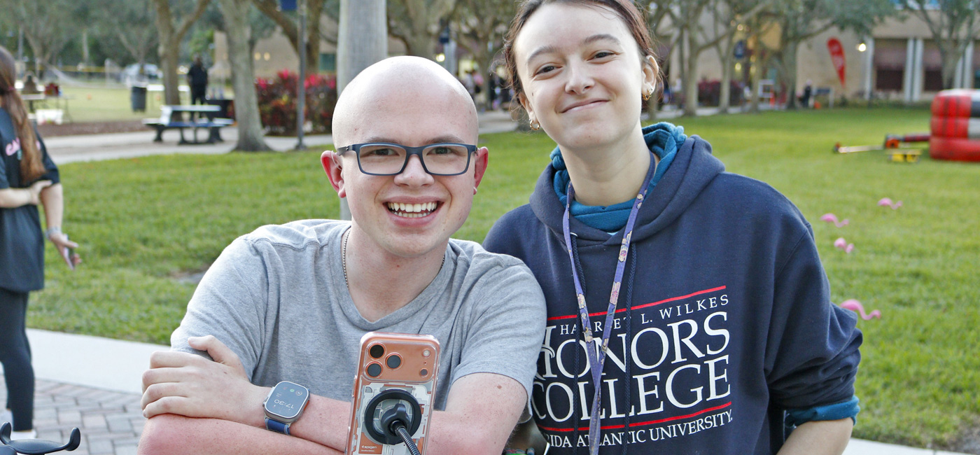 6 male students taking a photo in an open field on campus