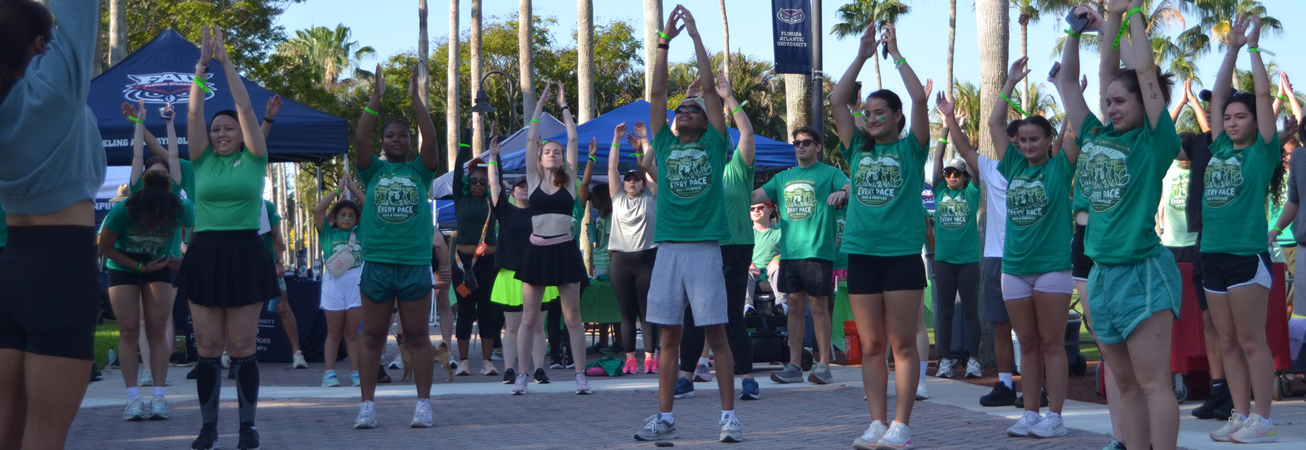 Students outdoors doing exercise green t-shirts