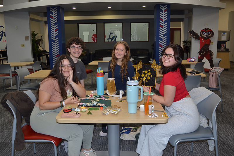 a group of student hanging out together on the Housing Lawn during Red and Blue Weeks