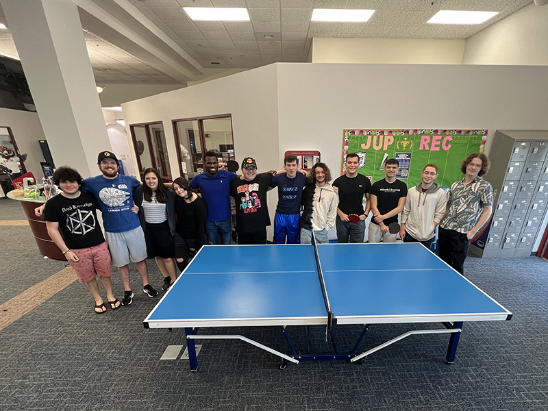 group photo behind a ping pong table