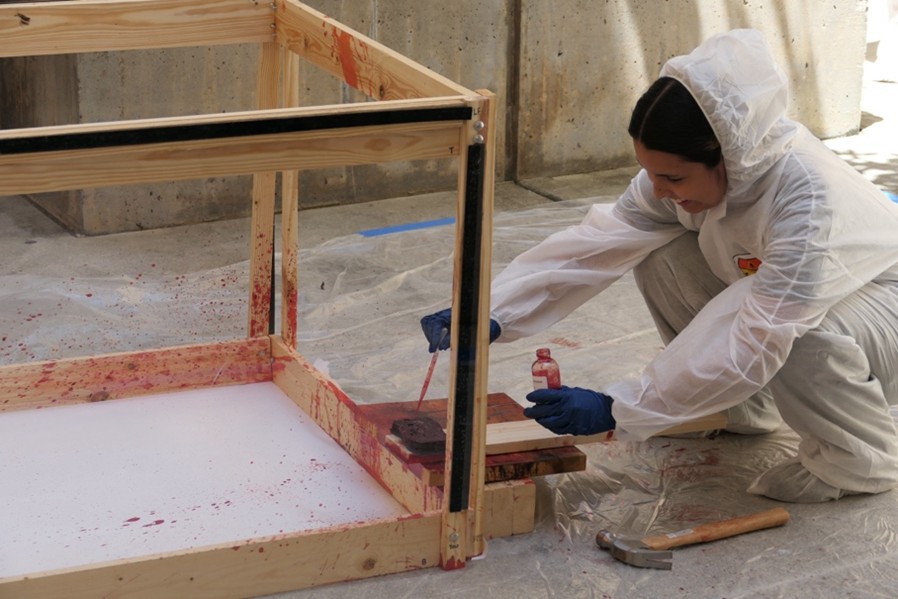 Student performing a blood splatter analysis at a mock crime scene