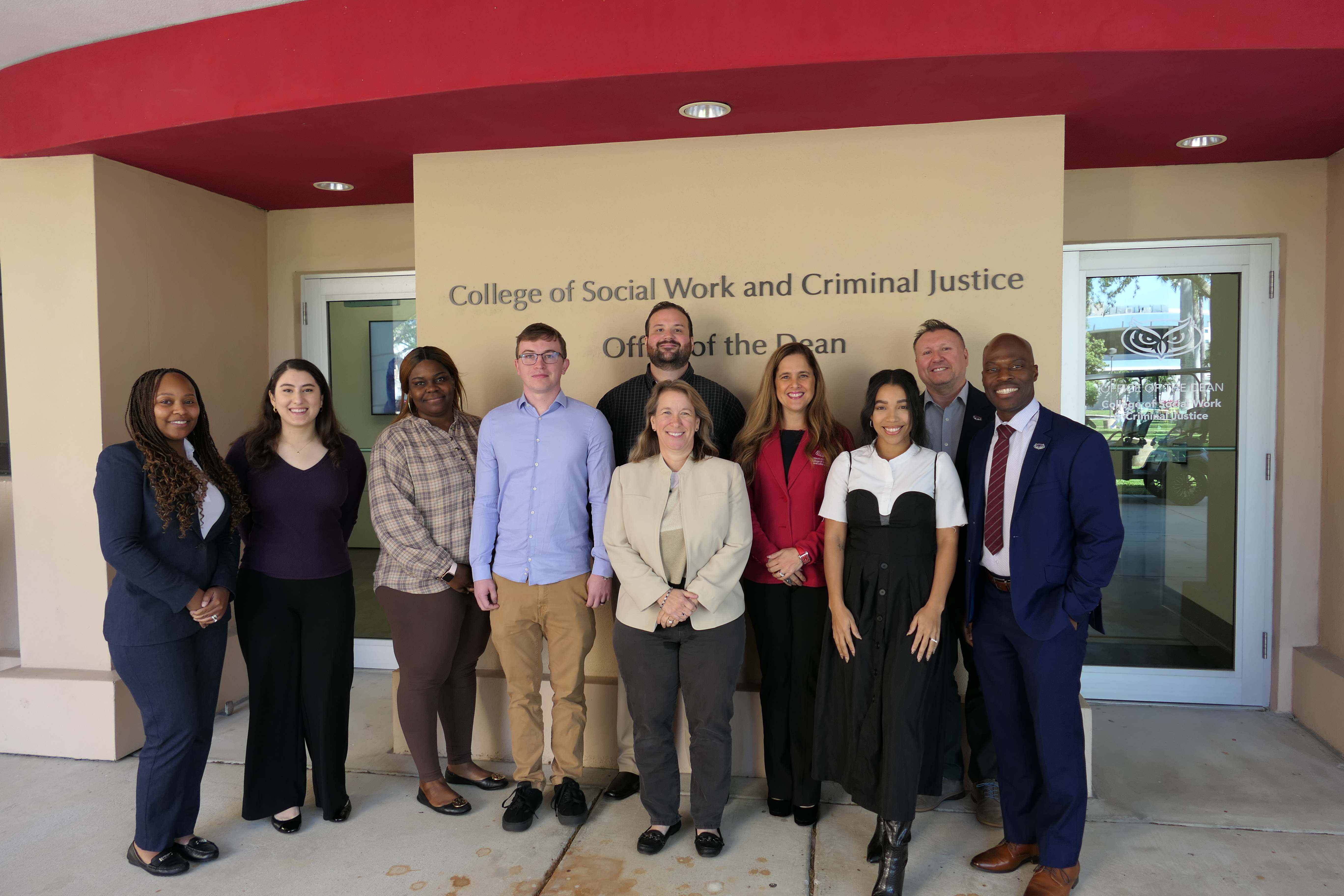 Dr. Schaeffer (center) with Dean Luna (in red), Dr. Precious Skinner-Osei (left), interim director of the Sandler School of Social Work, Dr. Tony Andenoro (second from right), director of community engagement and programming, and Tootie Martin (right), director of development, and five social work students who received $5,000 paid fellowships thanks to The Dr. Heidi Schaeffer Resilience, Hope, and Healing Fund.