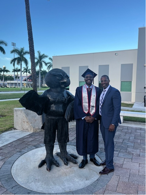 Kirk and his Son Malachia next to an Owlsey statue