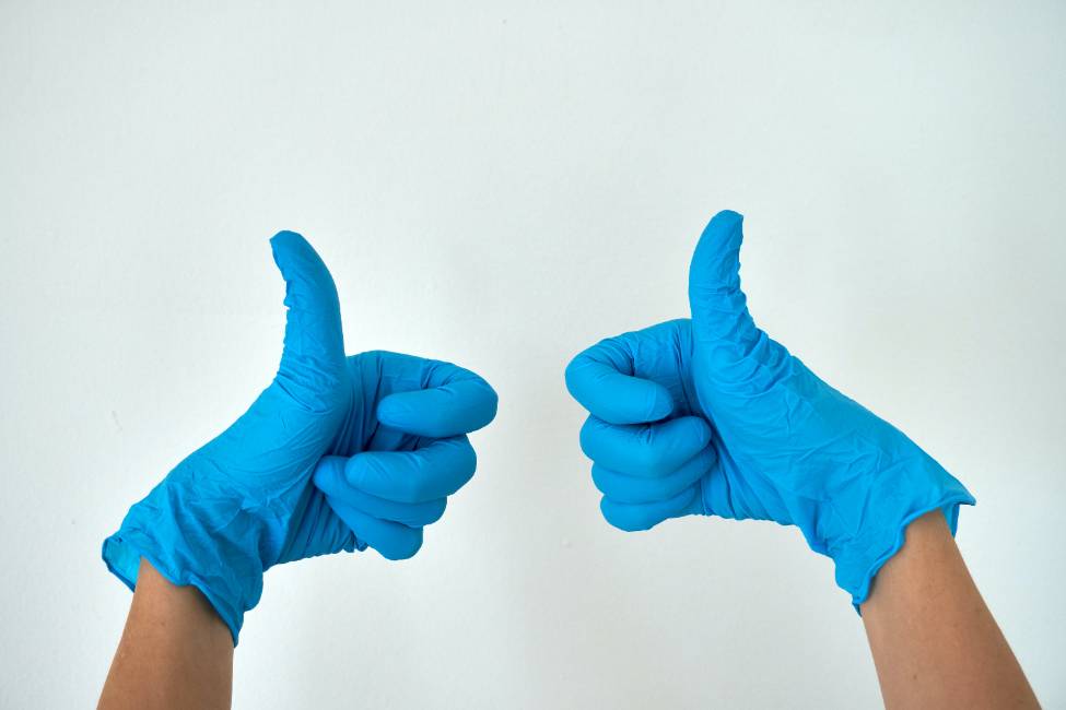 two thumbs up in latex gloves