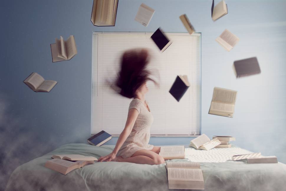 Girl with books thrown in the air