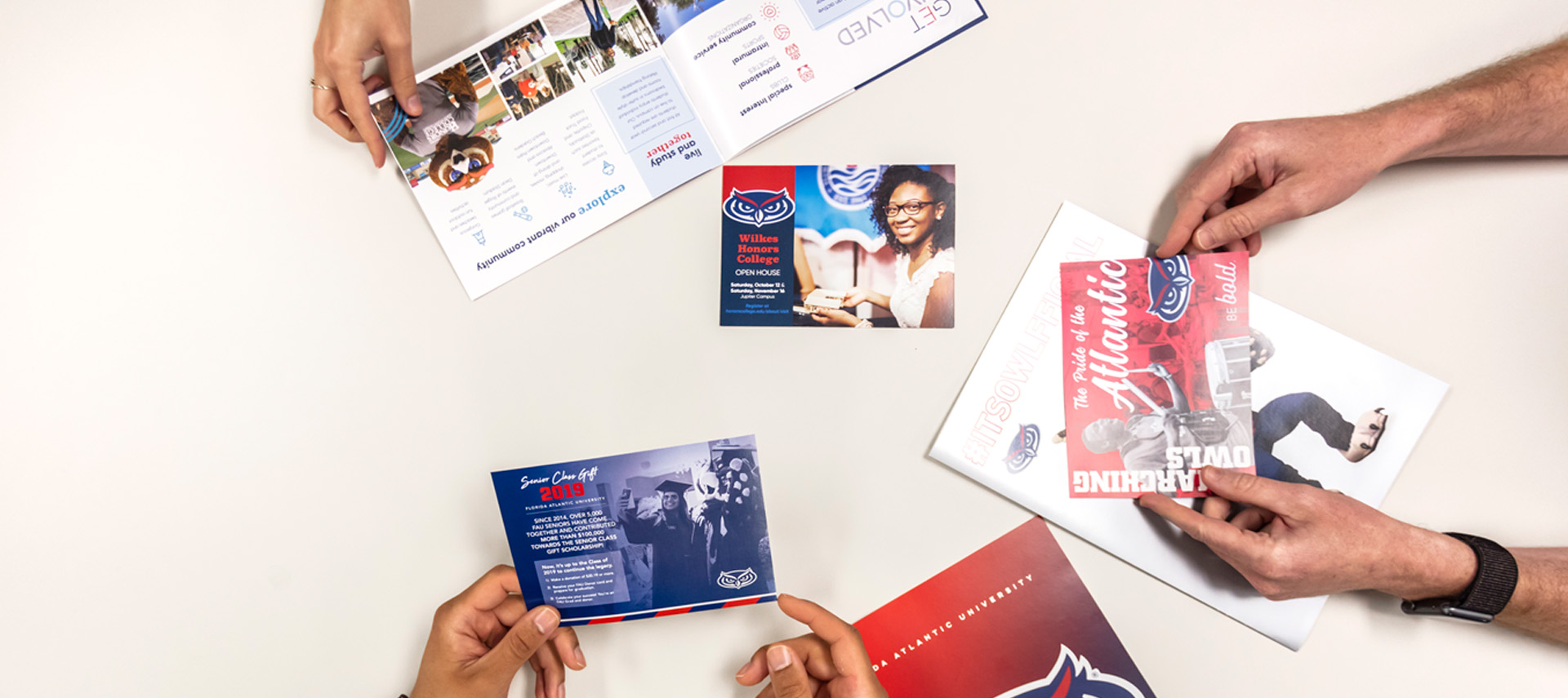 Hands holding cards, posters, magazines