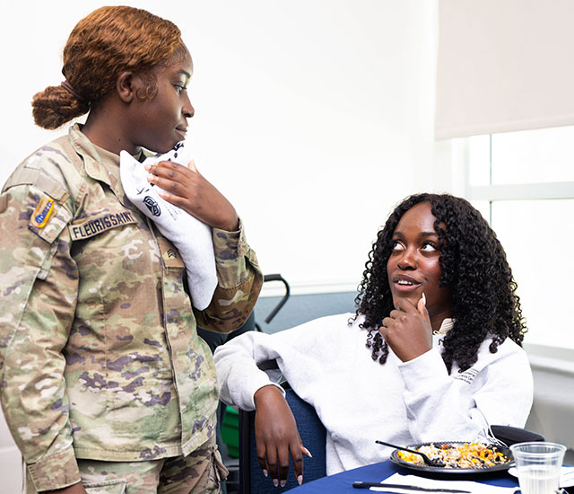 two students sitting and talking at a table