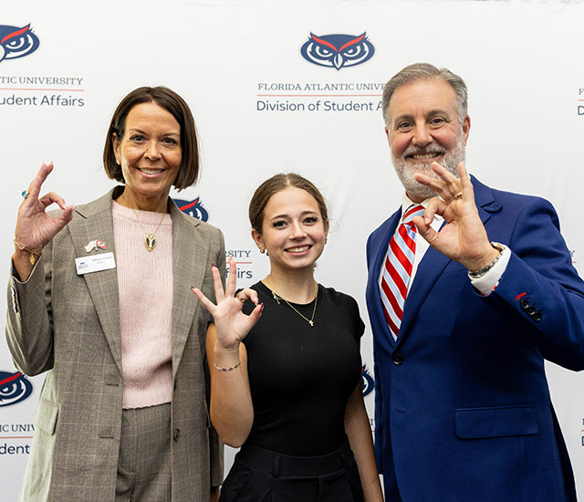 President Hasner posing with two staff members