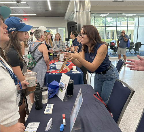 students getting information from a tabling event
