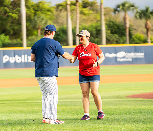Florida Atlantic grad walking shaking hands