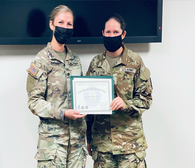 Two female student veterans standing with awards