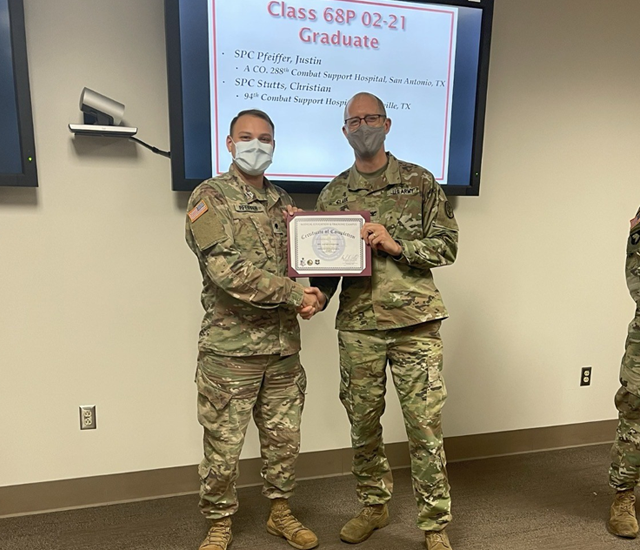 Two male student veterans standing with awards