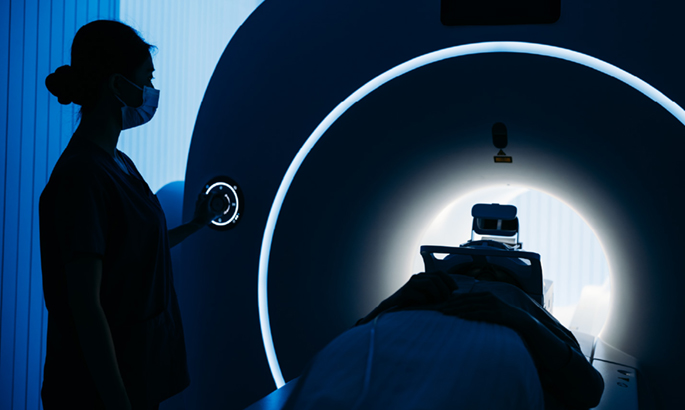 silhouette of mri machine and people on blue blackground